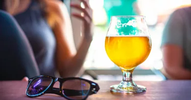 Bicchiere di birra su un tavolo con occhiali da sole in un'atmosfera estiva e rilassata